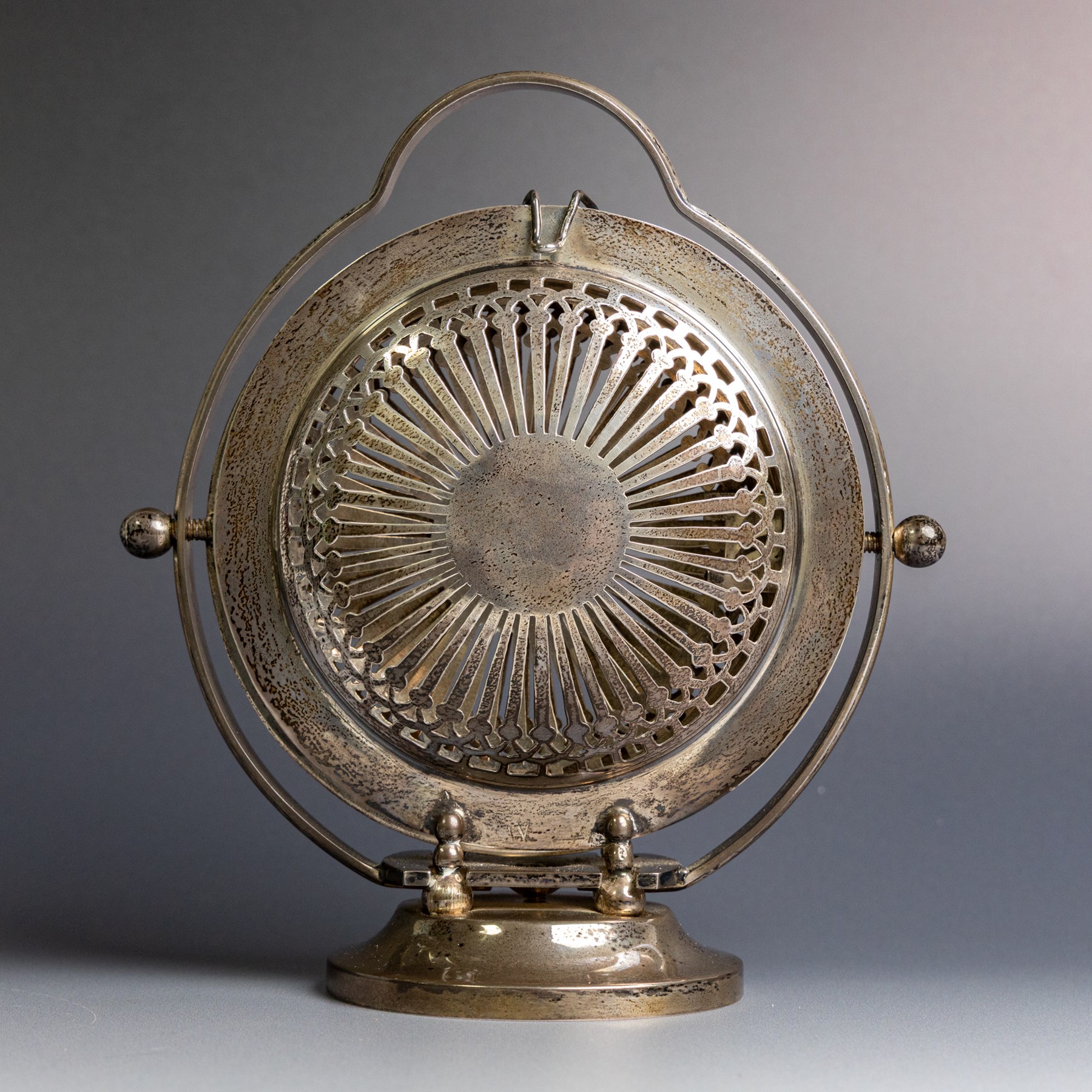 Indian silver folding cake stand, of circular form with pierced decoration, loop handle and circular foot, when folded H18cm