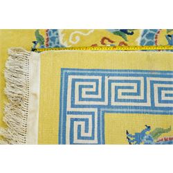 Modern Chinese hand-knotted wool pile carpet, golden field decorated with conforming dragons amidst stylized cloud scrolls enclosed by a Greek gey meander border, with cotton fringe ends 