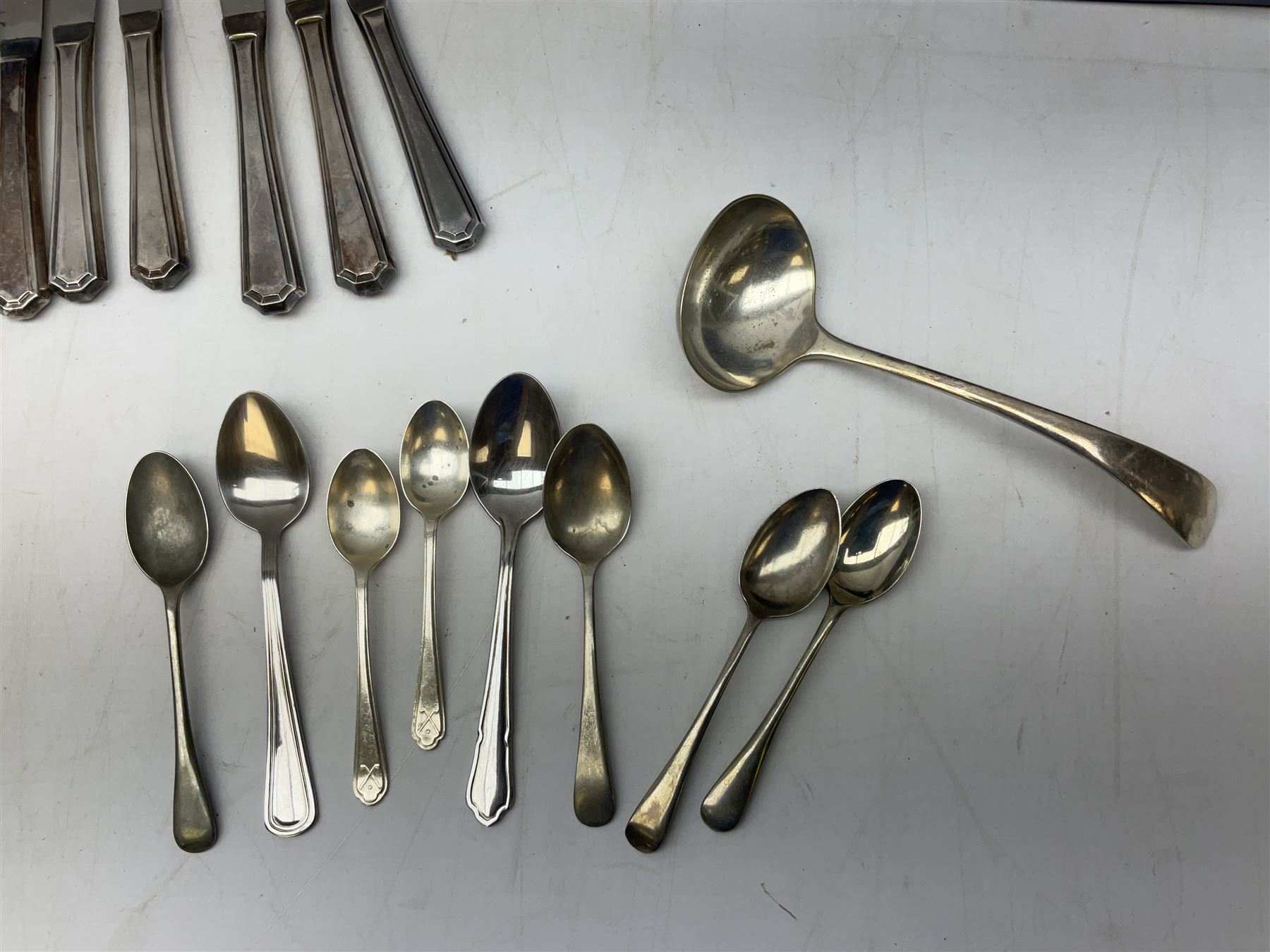 Four butter knives with hallmarked silver handles together with a Quantity of silver-plated cutlery stamped Ashberry and other stainless steel cutlery