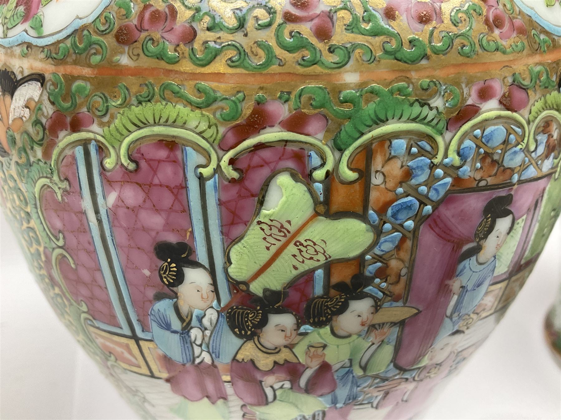 Pair of 19th century Chinese Famille Rose vases and covers, each of baluster form with twin gilt lion mask ring handles to shoulders, the flattened domed covers with gilt temple lion finials, each decorated with alternating reserves of bijin and attendants, and birds and butterflies amongst blossoming peonies, against a gilt ground profusely decorated with stylised scrolls, H32.5cm
