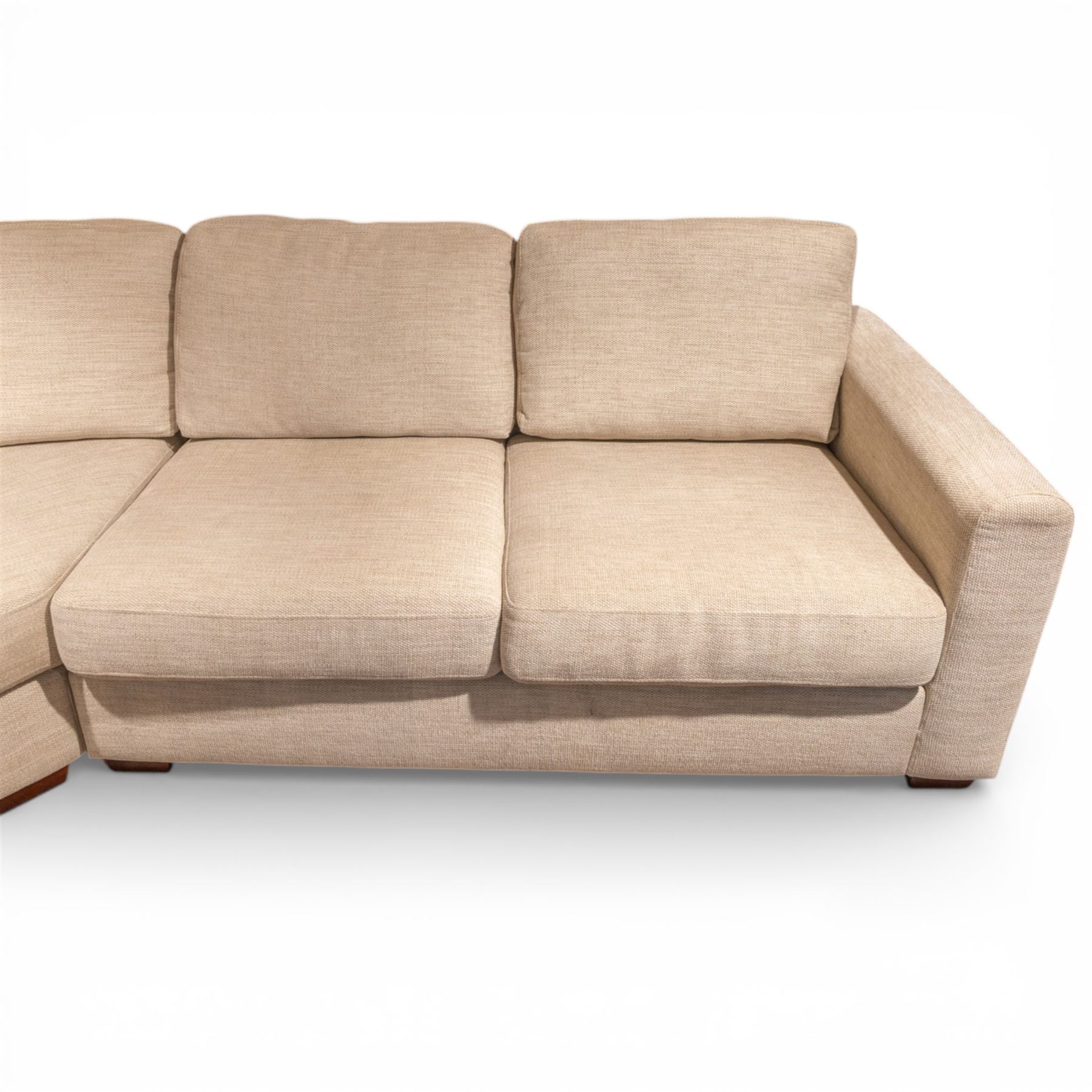 Contemporary modular corner sofa, upholstered in neutral fabric, with curved back fitted with loose cushions and wide seat pads, padded scroll arms and block feet, designed as three detachable sections