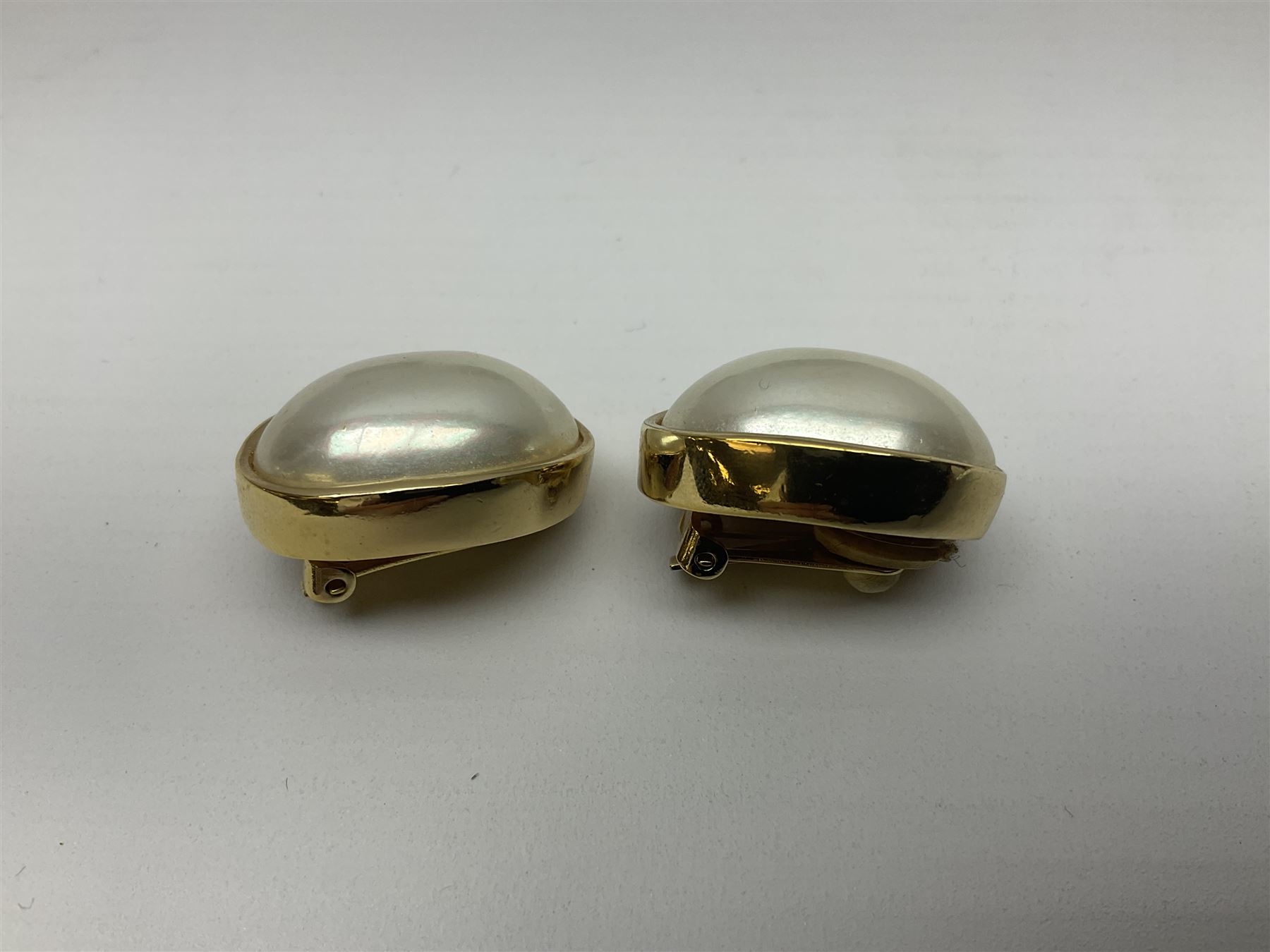 Christian Dior costume jewellery, comprising pair of pearlescent clip on earrings, enamel and paste leaf brooch and a pierced stylised leaf brooch, each stamped Chr.Dior Germany and in original boxes