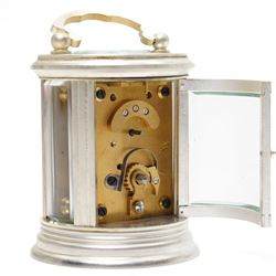 20th century-Silver plated 8-day timepiece carriage clock in an oval case, enamel dial with Roman numerals, minute track and steel moon hands, with an oval viewing class to the lever platform escapement. With key.