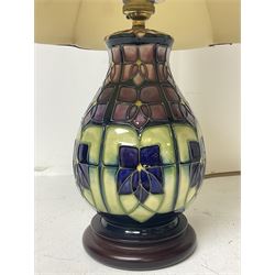 Moorcroft table lamp, of baluster form, decorated in the Violet pattern, on wooden plinth, with accompanying cream shade of lobed form, with piped detail, H23cm (excluding fitting)