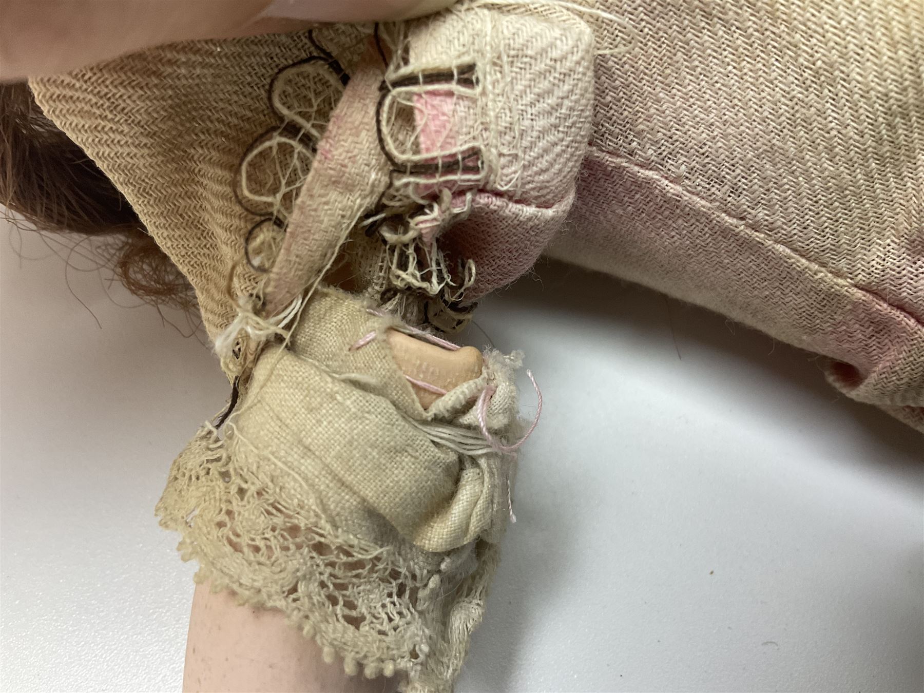 Victorian wax shoulder head doll with applied hair, inset glass eyes and jointed body with composition lower limbs; faded pink dress H35cm