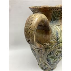 Early 20th century Royal Doulton stoneware vase, decorated with a stylized floral design below a wavy rim, monogrammed B.N, possibly for Bessie Newbery, H28cm, together with an early 20th century glazed jug, heavily carved throughout (2)