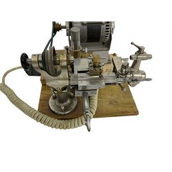 Lorch 6mm watchmakers lathe with tailstock, crosslide, tool rest, four-way tool post, pulleys and motor. Mounted on a wooden board.