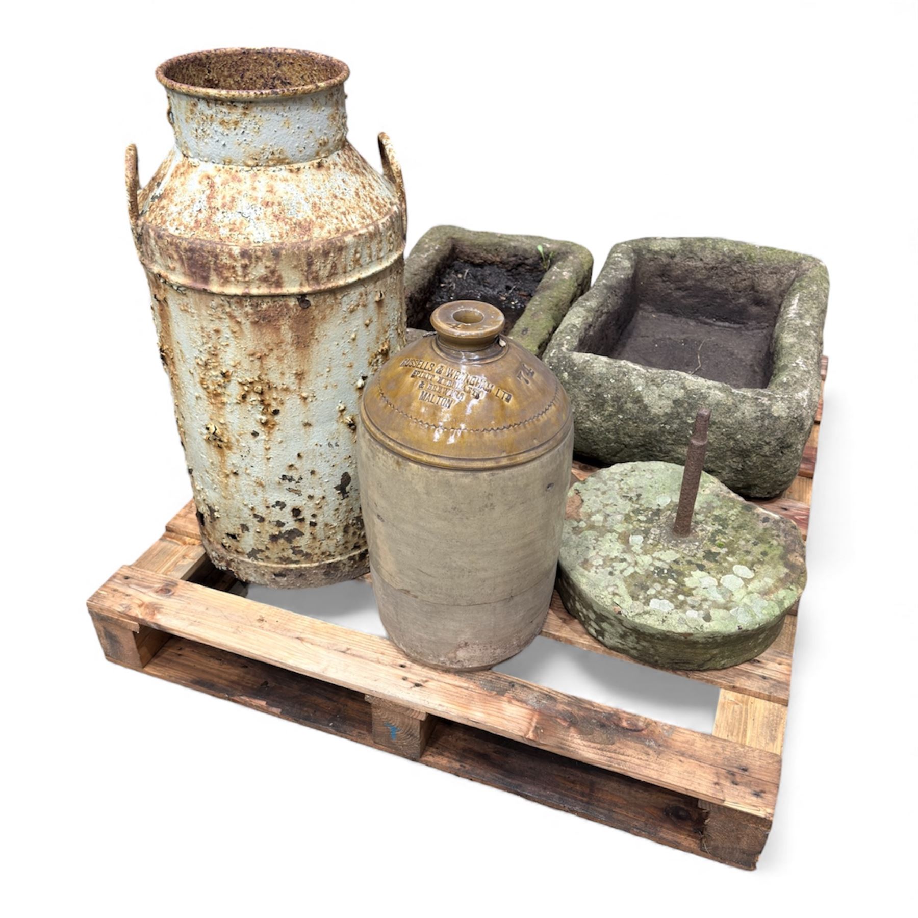 Two 19th century stone troughs, with mill stone, flagon and metal milk churn 
