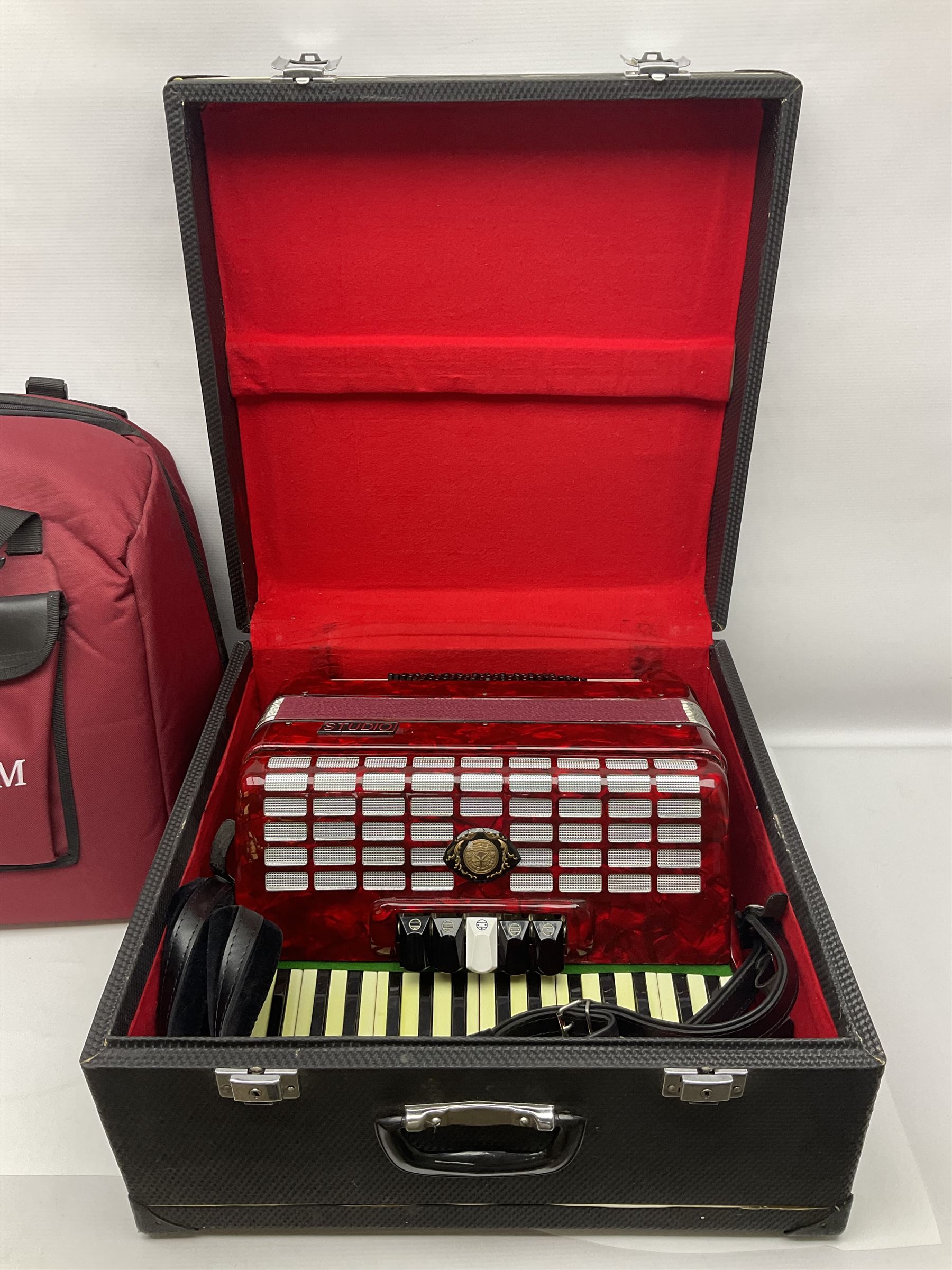 Hsinghai Studio piano accordion with red pearline finish, twenty keys and seventy-two buttons W44cm; in hard carrying case with additional The Music Room soft gig case