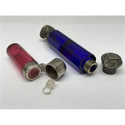 Late Victorian silver mounted ruby glass cylindrical scent bottle, with interior glass stopper, Birmingham 1900, makers mark worn, H8cm, together with a Victorian double ended cut blue glass perfume bottle mounted with white metal screw and flip caps decorated with foliate repousse detailing, H13.5cm