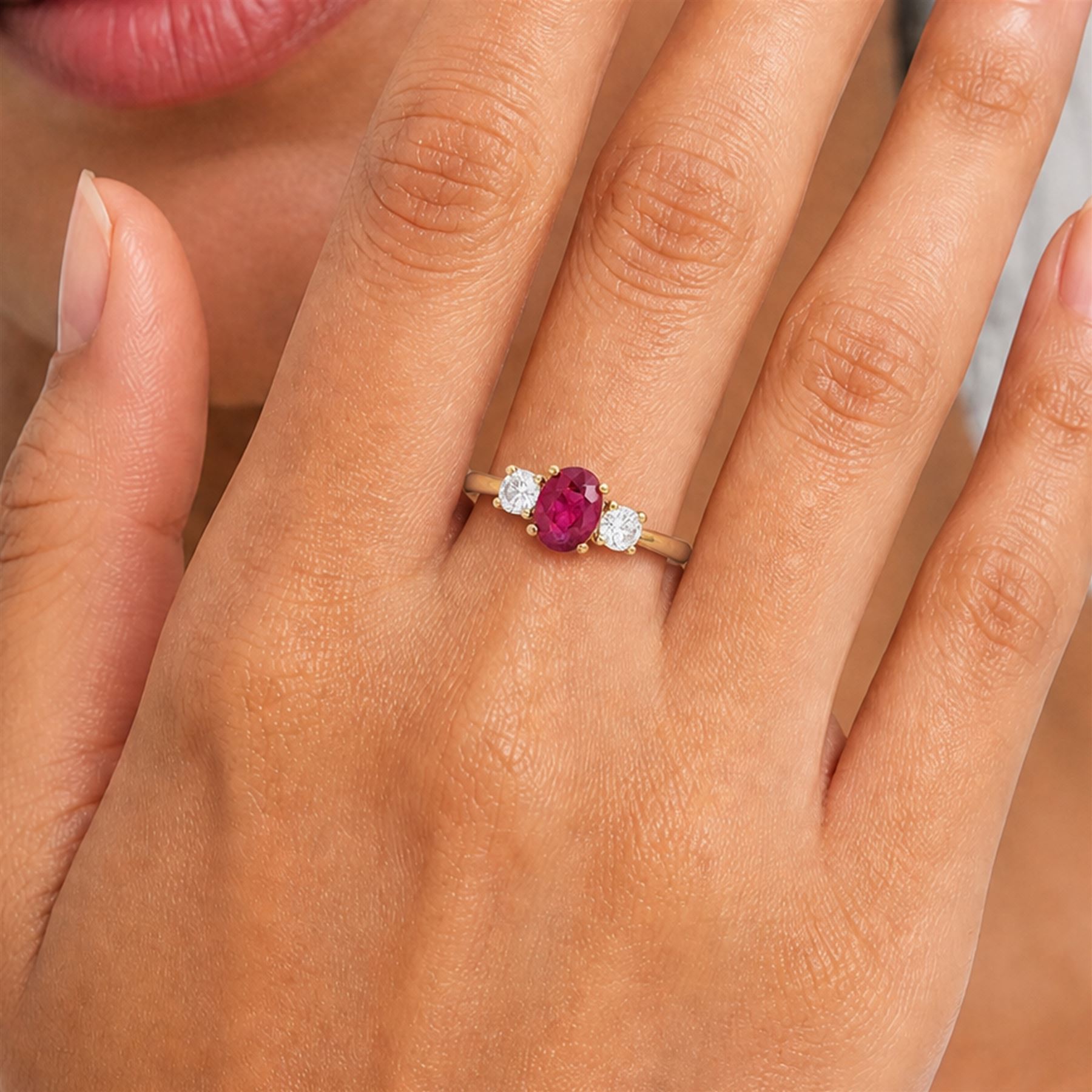 18ct gold ruby and diamond three stone ring, single oval cut ruby of 1.06 carat, with a round brilliant cut diamond set either side, hallmarked, total diamond weight 0.31 carat