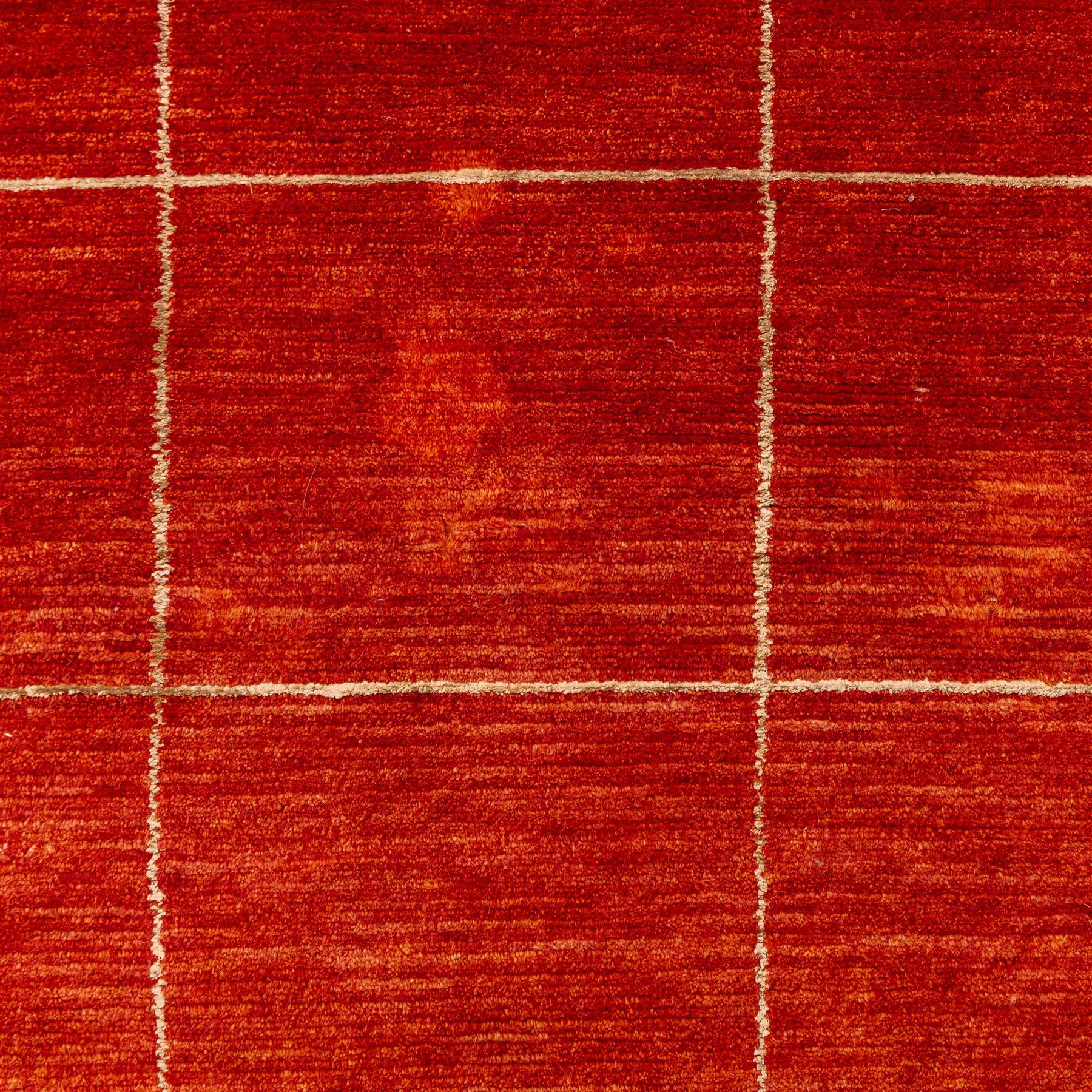Two contemporary Moroccan Berber hand-woven rugs, deep madder red field of plain design, 199x153cm, other with deep madder red field with a simple lattice of ivory lines forming panels with some tonal variation, 190x146cm 