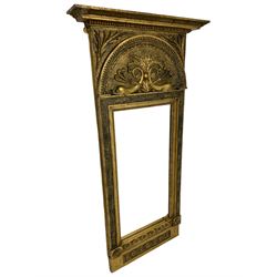 19th century Swedish Neo-Classical pier mirror, the projecting moulded cornice over arched frieze decorated with dolphins and scrolled foliate decoration, the frame decorated with flower head motifs with extending foliage, paper label to the reverse inscribed ‘Tillverkad uti L.M. Thims Spegel Fabrik vid Stortorget Stockholm (Made in L.M. Thim's Mirror Factory at Stortorget Stockholm)’