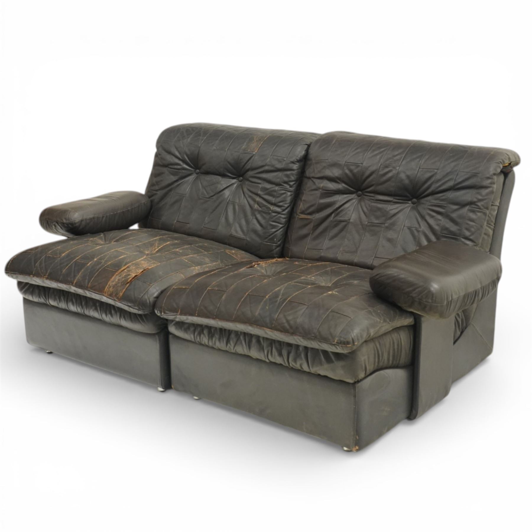 Mid 20th century leather upholstered two-piece sectional sofa with footstool, buttoned back cushions with stitched panel decoration, padded armrests and deep seat cushions, raised on concealed supports