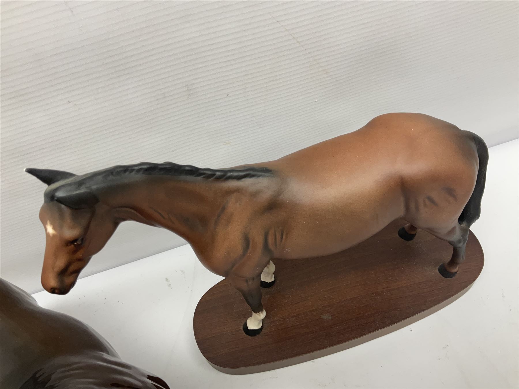 Four Beswick horse figures, comprising Quarter Horse, two Shires no 818 and matt palomino, together with Beswick donkey and Royal Doulton horse on a wooden plinth  
