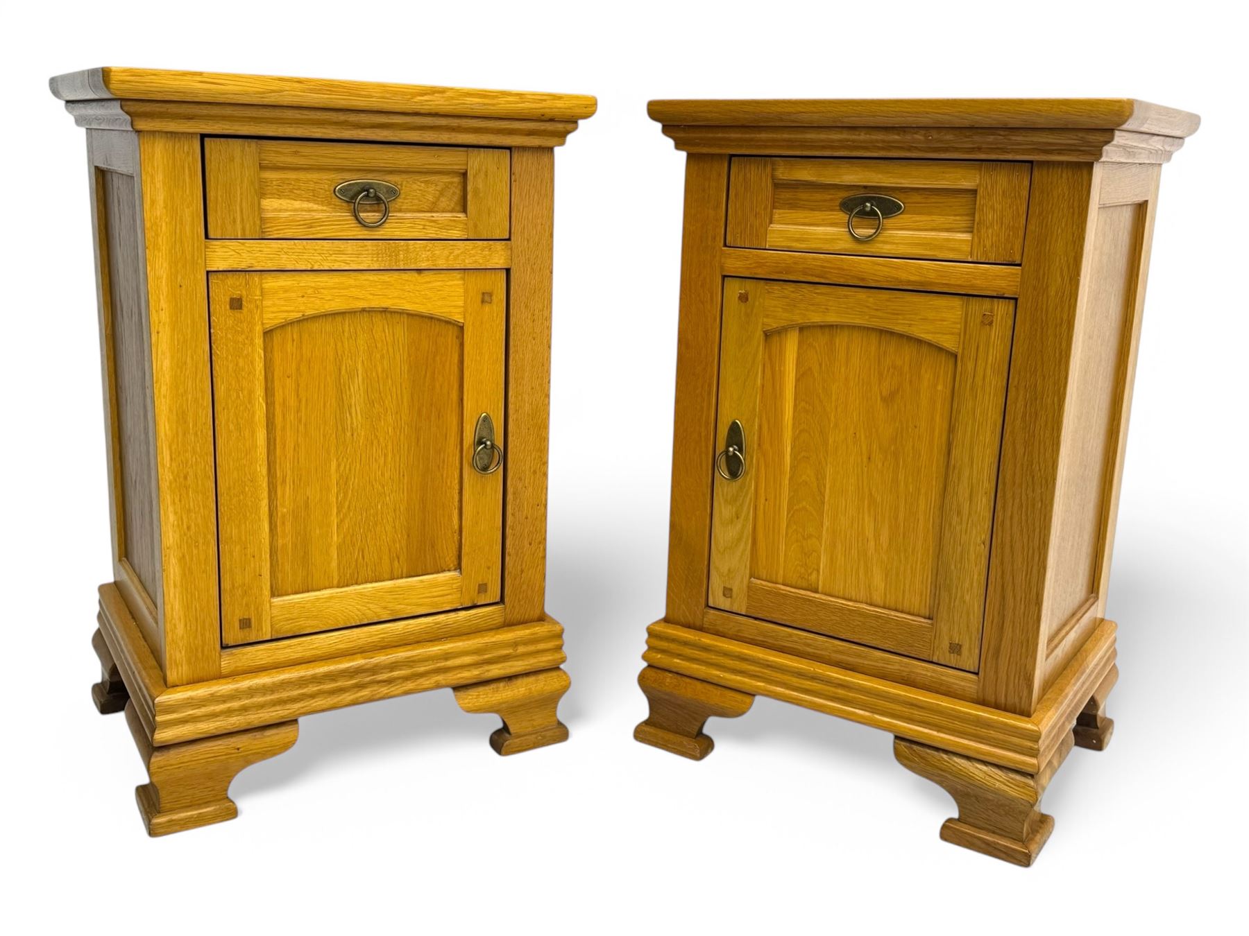 Frank Hudson - contemporary pair of light oak bedside cabinets, each with moulded rectangular top over single drawer above cupboard door with arched panel, on a moulded plinth base with bracket feet