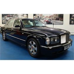 2001 Bentley Arnage Red Label Saloon

Registration: BU51 TGX
Engine: 6.75-litre turbocharged V8 petrol
Transmission: Automatic
Odometer reading: 39,942 miles
Colour: Black Sapphire metallic
Interior: Magnolia leather with burr walnut veneers
Previous owners: 3
V5C: Present
Service history: Good service records

An exceptional Bentley Arnage Red Label Saloon, finished in Black Sapphire metallic, a very dark blue, with a Magnolia leather interior, contrasting dark blue carpets and extensive burr walnut veneers. The car displays an odometer reading of approximately 39,942 miles.

The Arnage Red Label combined Bentley’s renowned 6.75-litre turbocharged V8 engine with automatic transmission, delivering effortless performance in a traditionally appointed luxury saloon. The model is distinguished by its imposing proportions, characteristic Bentley radiator grille and finely crafted interior.

Presented in excellent condition throughout, the bodywork and metallic paint finish appear particularly well preserved, complemented by clean brightwork and the correct Bentley alloy wheels. The engine bay is also notably well detailed.

The interior presents exceptionally well, retaining its Magnolia leather upholstery, polished burr walnut veneers, original factory instrumentation and switchgear. The leather displays only light creasing consistent with careful use.

The car has had three previous owners and is accompanied by good service records.

Features

• 6.75-litre turbocharged V8 petrol engine
• Automatic transmission
• Black Sapphire metallic paintwork
• Magnolia leather interior
• Contrasting dark blue carpets
• Burr walnut veneers
• Electrically adjustable front seats
• Air conditioning
• Factory instrumentation and switchgear
• Bentley alloy wheels
• Right-hand drive
• Odometer reading of approximately 39,942 miles
• Three previous owners
• Good service records
• V5C present

This vehicle forms part of the Estate of the Late John Sills and is offered for sale by the Executors, confirming a genuine reason for sale.