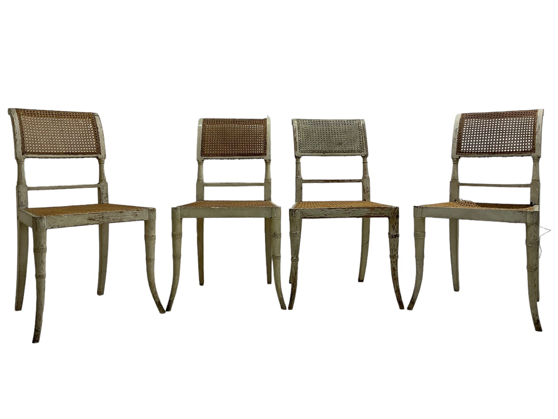 Collection of Regency dining chairs - set of four Regency painted beech dining chairs, with cane seat and back, on collar turned supports with splayed feet (W46cm, H84cm); a pair of Regency ebonised dining chairs (W47cm, H77cm); and a single Regency dining chair, the cresting rail painted with floral cornucopias and central putto vignette, X-frame back over cane seat, on collar turned front supports painted with foliage (W46cm, H84cm) (7)