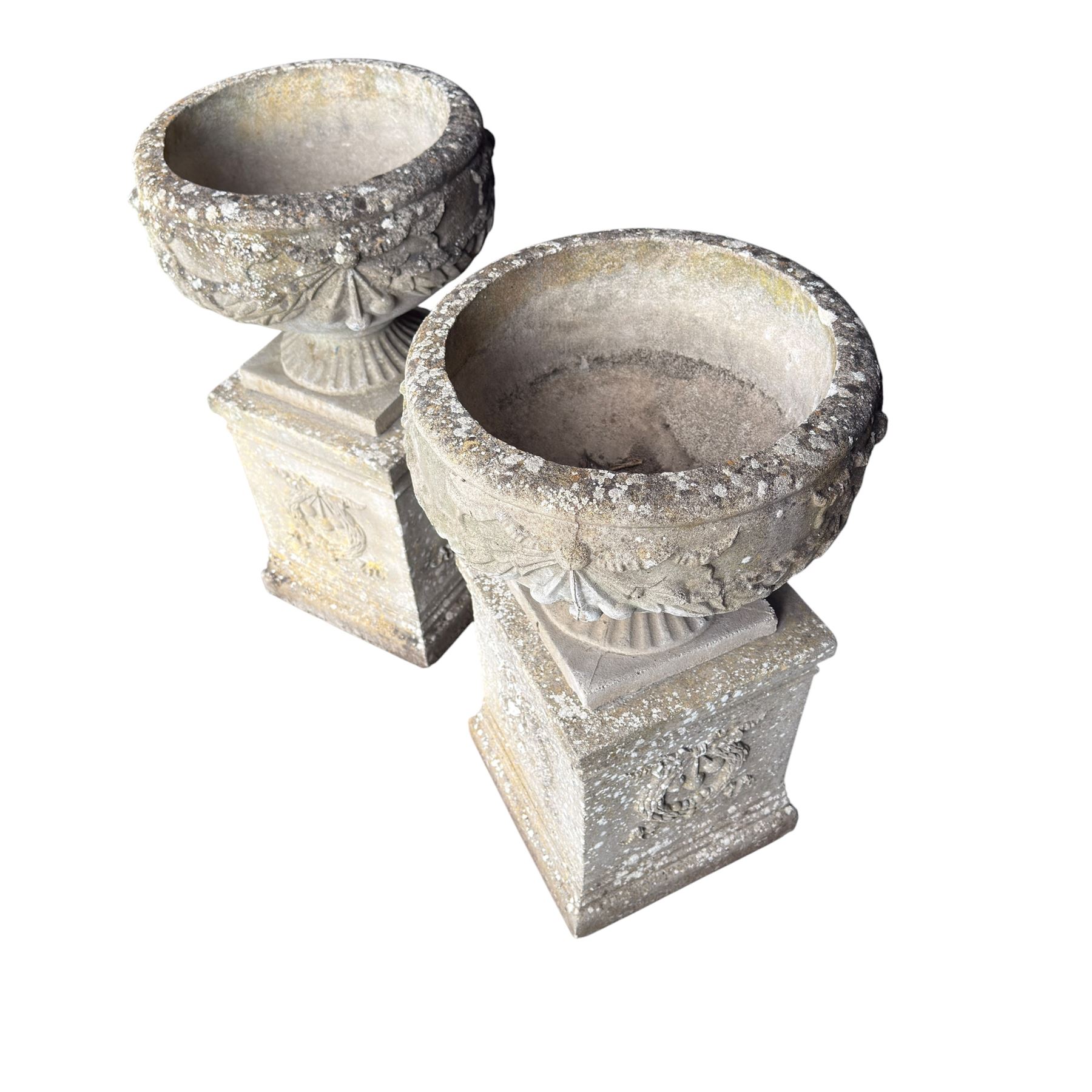 Pair of quality Neoclassical design Haddonstone cast stone garden urns, the globular  body decorated with relief foliate festoons and fruiting motifs, over a fluted socle, the rectangular pedestals with relief foliate wreaths and ribbon garlands
