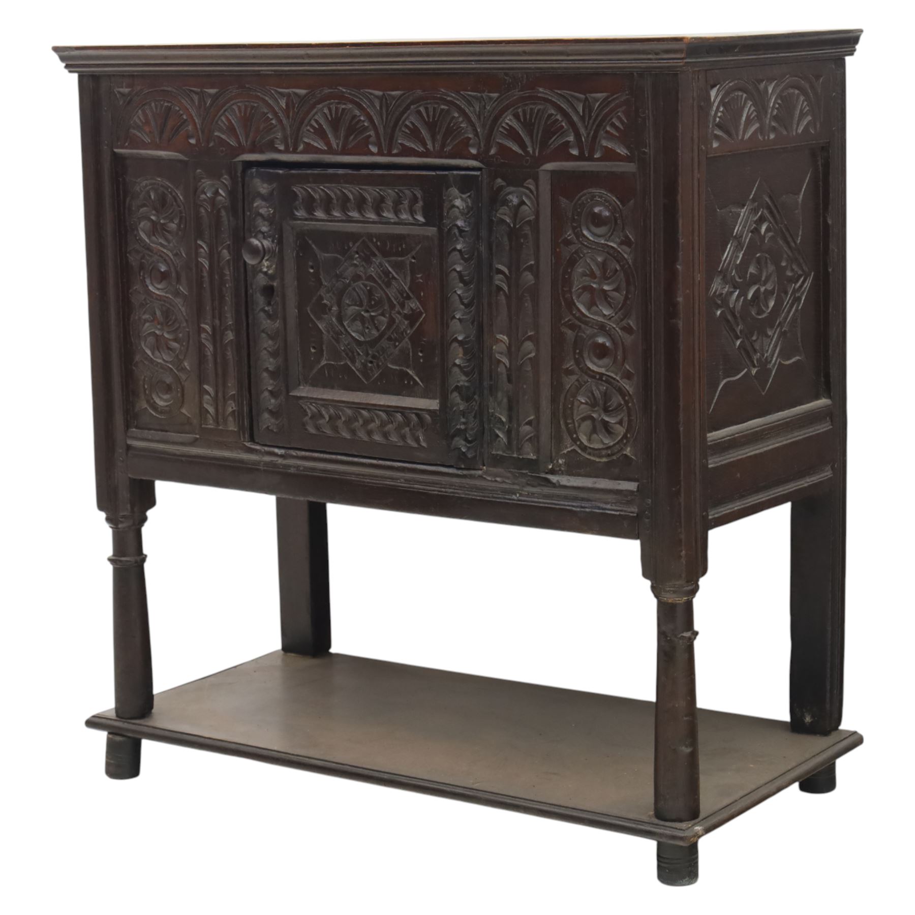 19th century oak cupboard cabinet, the moulded rectangular top above a deeply carved front carved with frieze of lunettes above a central panelled cupboard door with lozenge and foliate carving, flanked by vertical carved panels, upon turned legs with boarded lower shelf