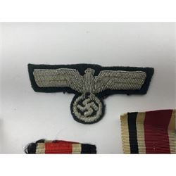 WWII German Iron Cross 2nd Class, the suspension ring stamped 128 for S. Jablonski G.m.b.H. Posen; with ribbon; together with an embroidered cloth eagle badge and quantity of German medal ribbons.