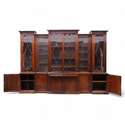 Large Georgian mahogany library bookcase, projecting moulded cornice with row of globular mounts, adjustable shelving enclosed by six astragal glazed doors, fitted with two slides and six panelled cupboard doors, two banks of five drawers, on moulded plinth base; together with two pairs of associated astragal glazed doors in mahogany, from the same property (W55.5cm x H168cm & W48cm x 168cm)