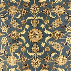 Central Persian Kashan rug, densely knotted, in a teal and cream ground, central medallion with circular rosette surrounded by a highly detailed field of radiating palmettes, vine arabesque patterns, rosettes, and  lotus blossoms, main border with alternating palmettes flanked by two narrower guard borders with a repeating floral meander design 