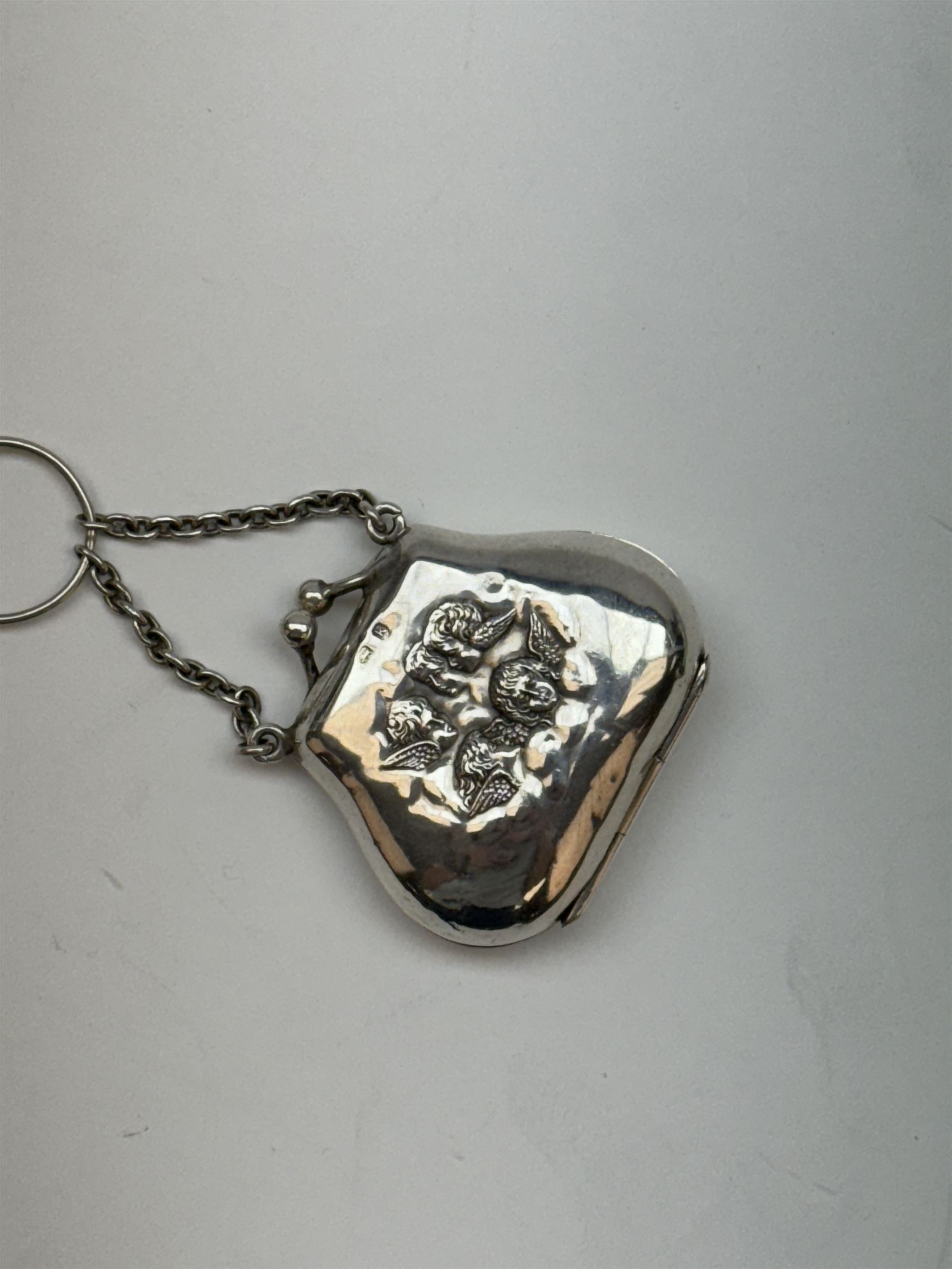 Victorian and later silver chatelaine, the shaped and foliate pierced clasp with embossed oval panel of a courting couple, hallmarked Levi & Salaman, Birmingham 1899, supporting six accessories on five chains: a circular mirror embossed with putti, hallmarked Henry Matthews, Birmingham 1911, pencil holder engraved with foliate scrolls, hallmarked Francis Webb, Birmingham 1914, conical scent bottle decorated with bamboo, (unmarked but testing as silver), aide memoire embossed with putti, hallmarked Samuel M Levi, Birmingham 1911, tape measure of compressed spherical form, hallmarked Henry Matthews, Birmingham 1899, and a purse with embossed putti, hallmarked Birmingham 1909, makers mark worn and indistinct, at longest point L31cm

