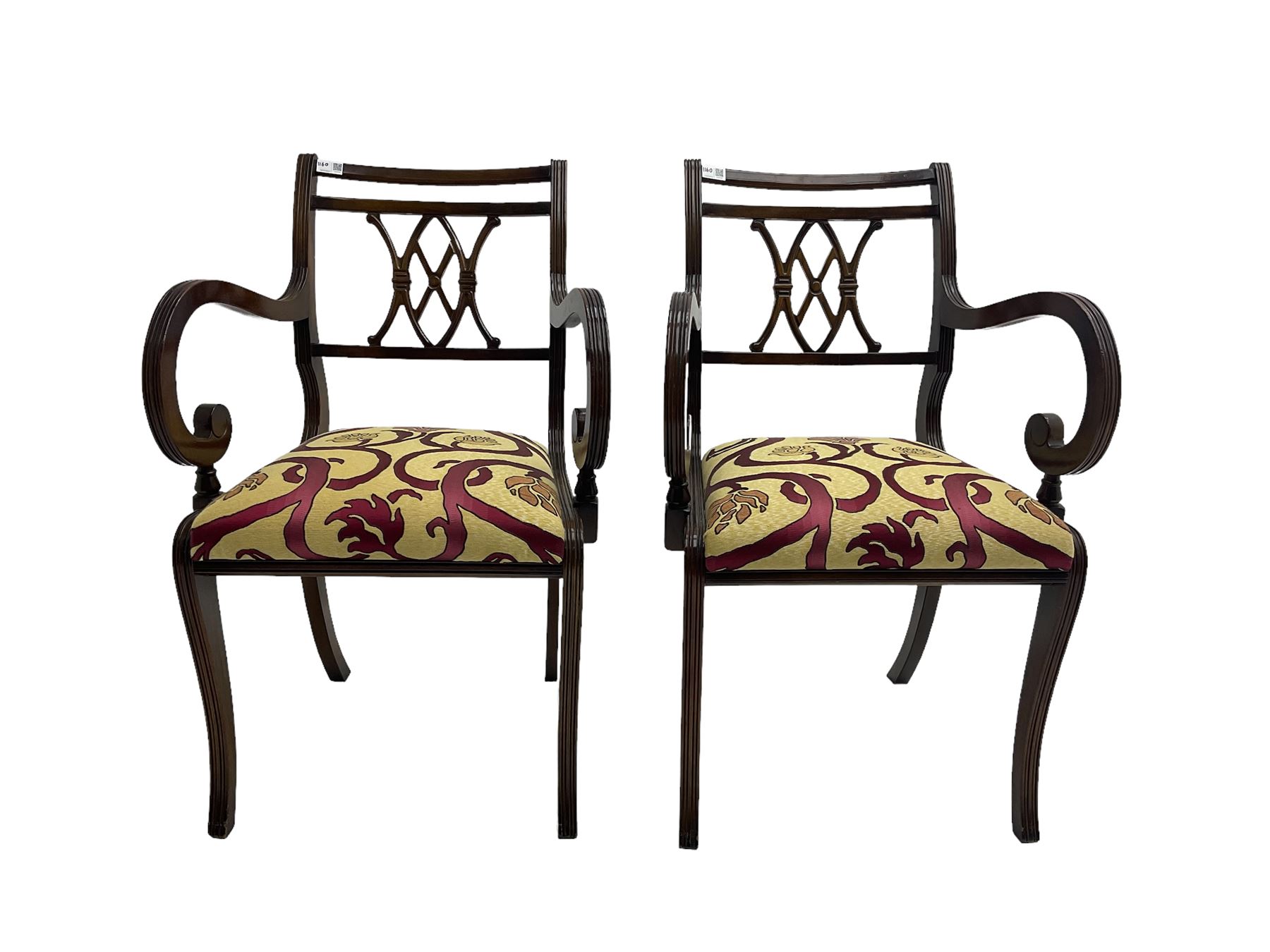 Regency design mahogany twin pedestal dining table, rectangular top with reeded edge, acanthus carved turned column terminating in reeded tripod base with hairy paw feet and castors (W172cm D92cm H75cm) and set eight (6+2) Regency design mahogany dining chairs, pierced back with scroll design, seat upholstered in patterned laurel green fabric, raised on reeded sabre supports (W48cm H88cm)