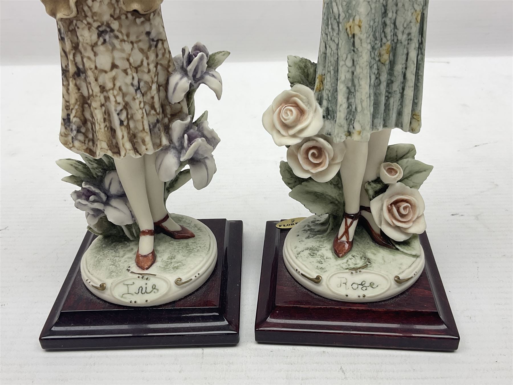 Set of four Giuseppe Armani Florence figures, Iris, Rose, Lily and Daisy, each modelled as ladies in 1920s dress amongst flowers, with names and signature inscribed and upon mahogany base, H23cm