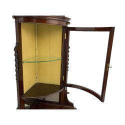 Edwardian mahogany floor-standing corner cabinet, cylinder glazed door above mirror backed shelf, the lower tier with fretwork back, on leaf carved and reeded tapering supports 