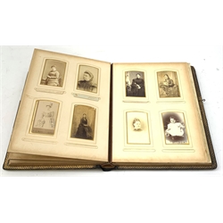 A Victorian photograph musical album, the tooled gilt leather bound album opening to reveal various portraits, and a musical movement, with key and instruction card.
