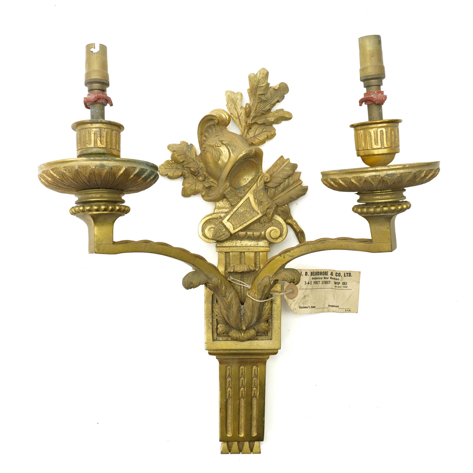 Period design gilt brass wall light, by Beardmore, London, with French empire motifs, including a helmet, oak leaves and acorns, quiver, each arm with acanthus leaf decoration, wired for electricity, with original label, H36cm  
Provenance: property of a Nobleman