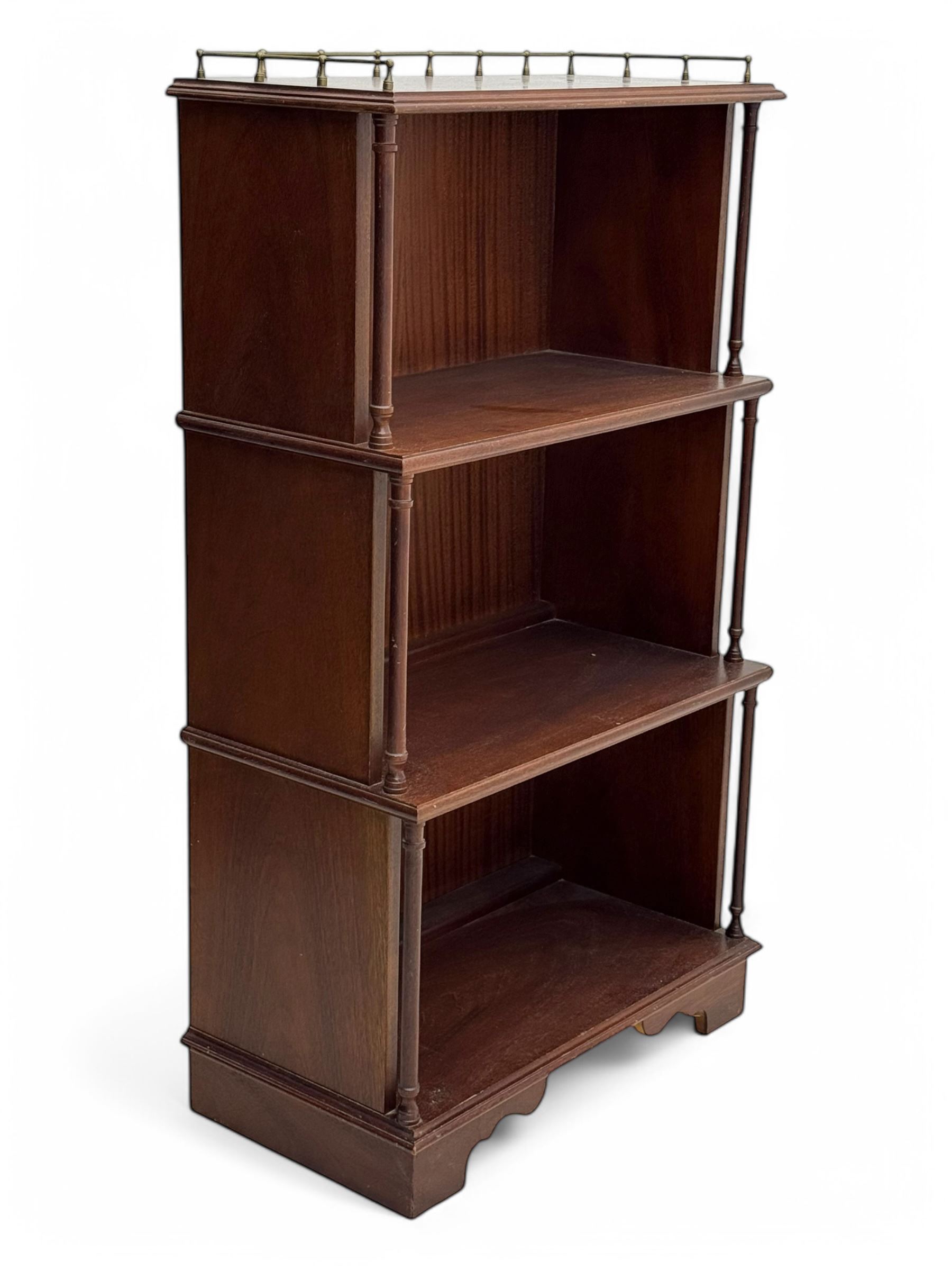 Mid-20th century mahogany open bookshelf, the rectangular top with a brass balustrade gallery, over three shelves each supported by turned column uprights, on shaped apron base