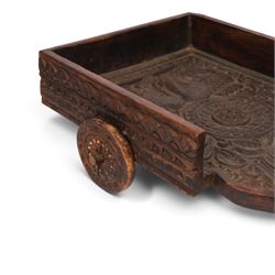 Indian carved wooden tray on wheels, the front carved as a horses head, the cart with foliate details, H28cm