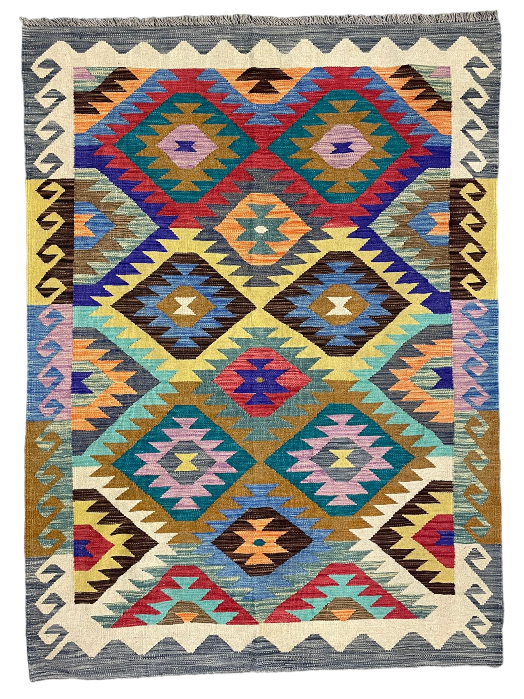 Anatolian Turkish Kilim rug, multi-coloured ground, decorated with geometric stepped lozenges with in a scrolled border