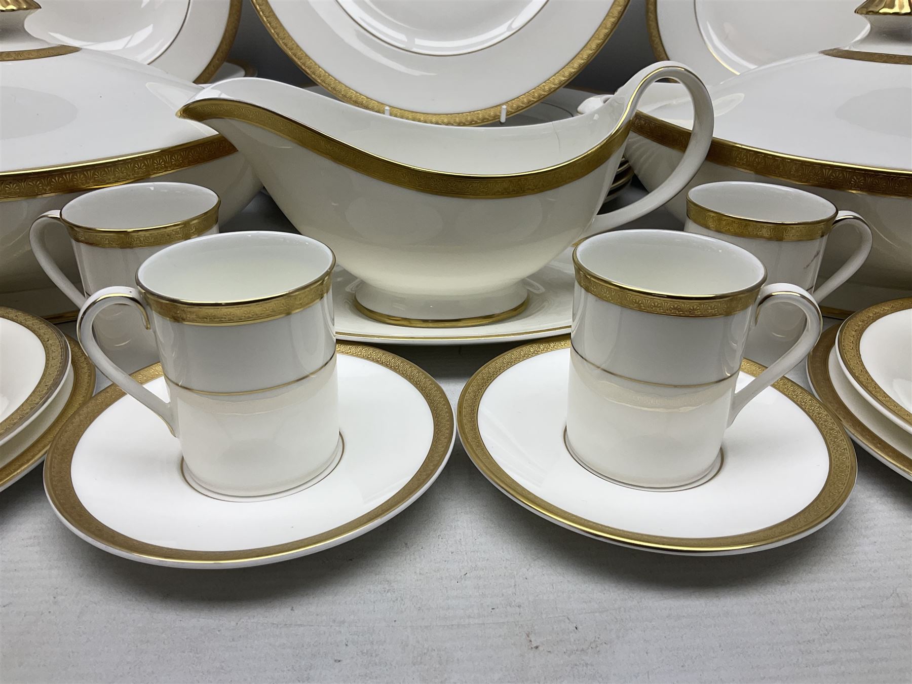 Royal Doulton Royal Gold pattern tea and dinner service for eight, comprising dinner plates, side plates, tea plates, soup bowls, sauce boat and saucer, dessert bowls, coffee cans and saucers, teacups and saucers and two lidded tureens