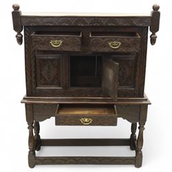 19th century and later carved oak court cupboard, the upper section with two drawers above a central cupboard door flanked by panels, lower section with single long drawer, on turned supports united by carved stretchers