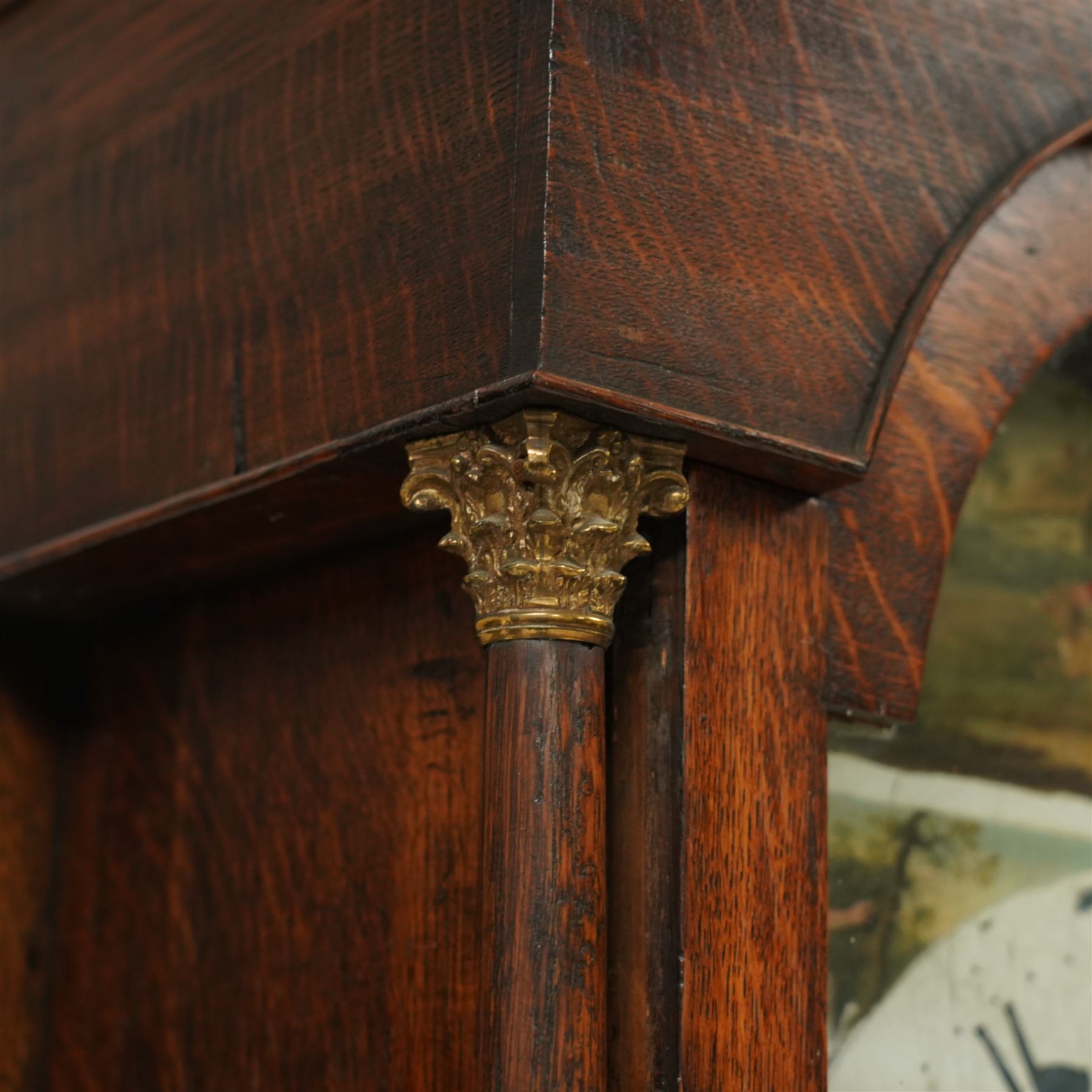 Mid-19th century-oak cased 8-day longcase clock, with a swan neck pediment, brass ball and spire finial and paterea, break arch hood door, detached pilasters with Corinthian brass capitals, trunk with canted corners and a spire topped door, square plinth with moulded feet, painted dial with images of the four seasons to the spandrels and a depiction of a boy and his dog to the arch, with Roman numerals, seconds and calendar dial and matching steel hands, dial pinned to a rack striking movement, striking the hours on a bell.