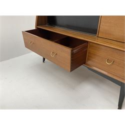 1950s G-Plan retro highboard unit, single long drawer above glazed sliding doors enclosing shaped glazed shelve, alongside a fall front door, above one short and one long drawer, raised on outsplayed tapering supports 