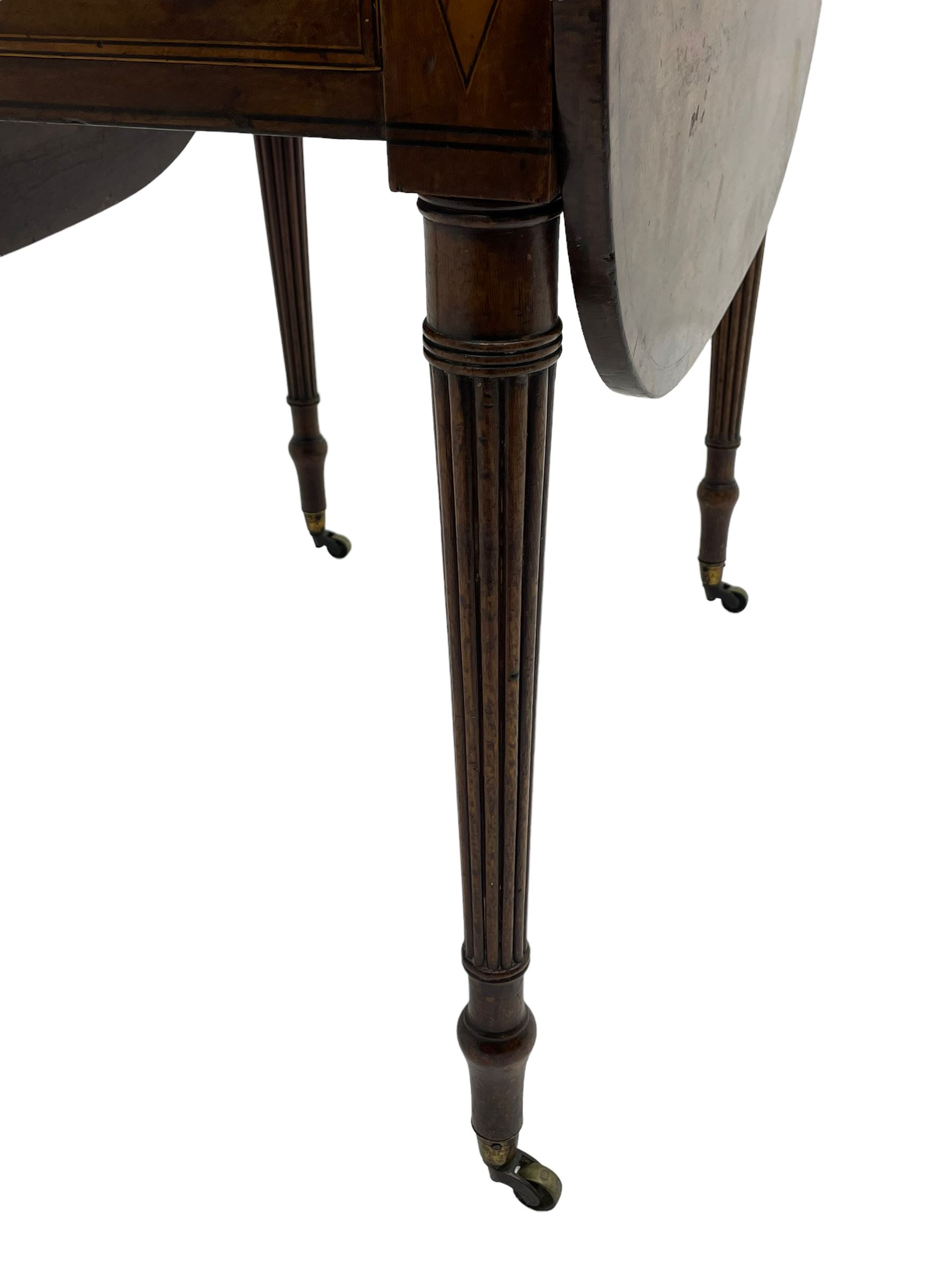 George III mahogany Pembroke table, drop-leaf oval top with satinwood band, fitted with single end drawer, inlaid with satinwood lozenge motifs, on turned and reeded supports with brass cups and castors