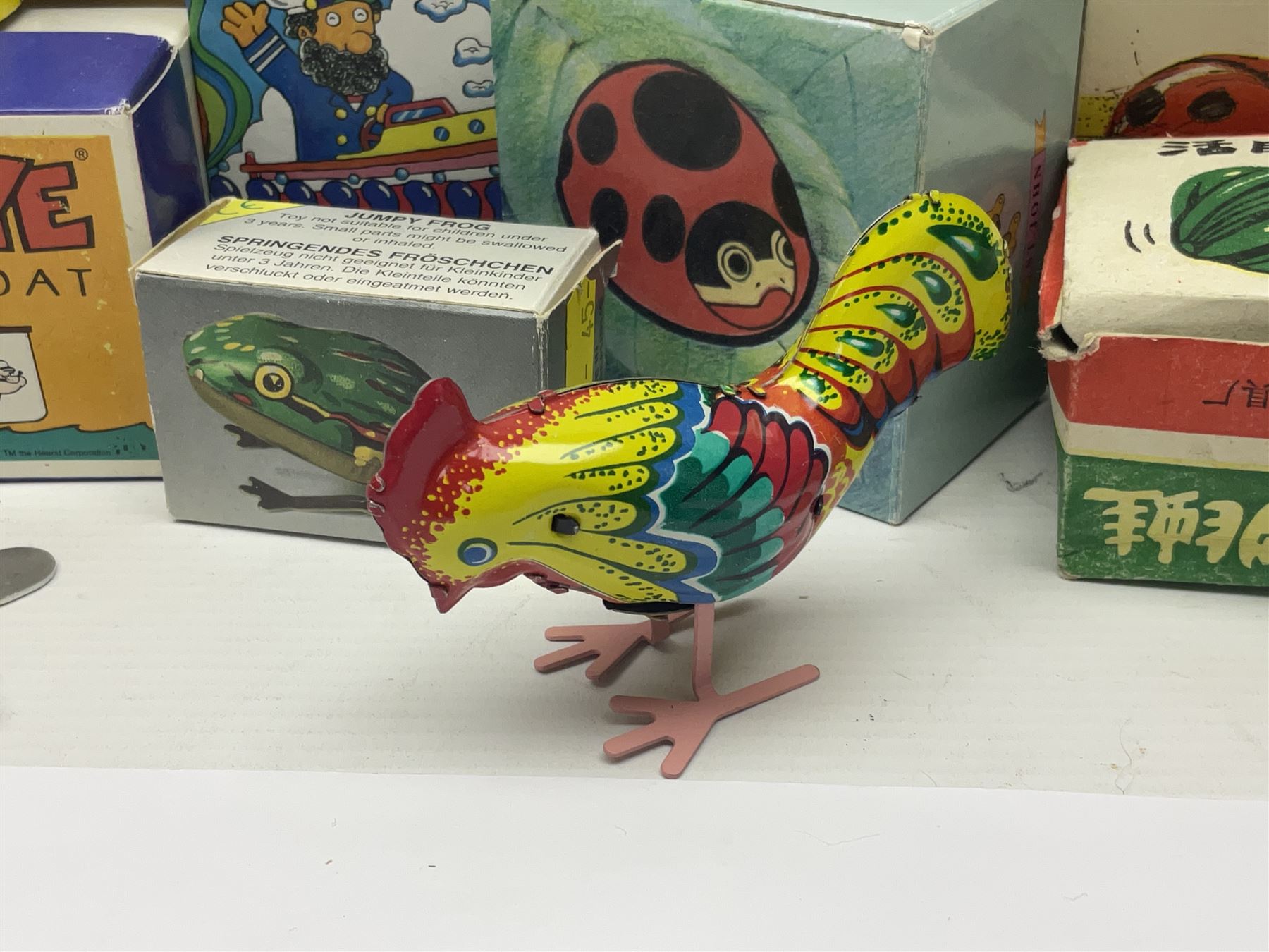 Twenty six tinplate models to include Ferris Wheel and Performing Circus Elephant, marked JW, further similar examples such as Duck on a Bike, Clown on Roller, Carousel; Popeye Tin Speedboat; Looney Tunes Wind Up Cars and Express Train; various international examples, MS107 Jumping Bambi, Pop Pop Boat, jumping frogs, pecking chickens etc; both boxed and loose