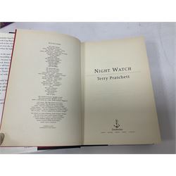 Collection of books by Terry Pratchett, of mostly Discworld interest, to include hardback edition of Going Postal, and further books such as Men at Arms, Sourcery, Small Gods etc 