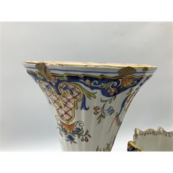 Two French faience polychrome vases and twin handled planter, all decorated with yellow baskets of flowers hanging from ribbons and further blue and orange scrolling foliate designs, tallest H28.5cm, all with painted marks beneath
