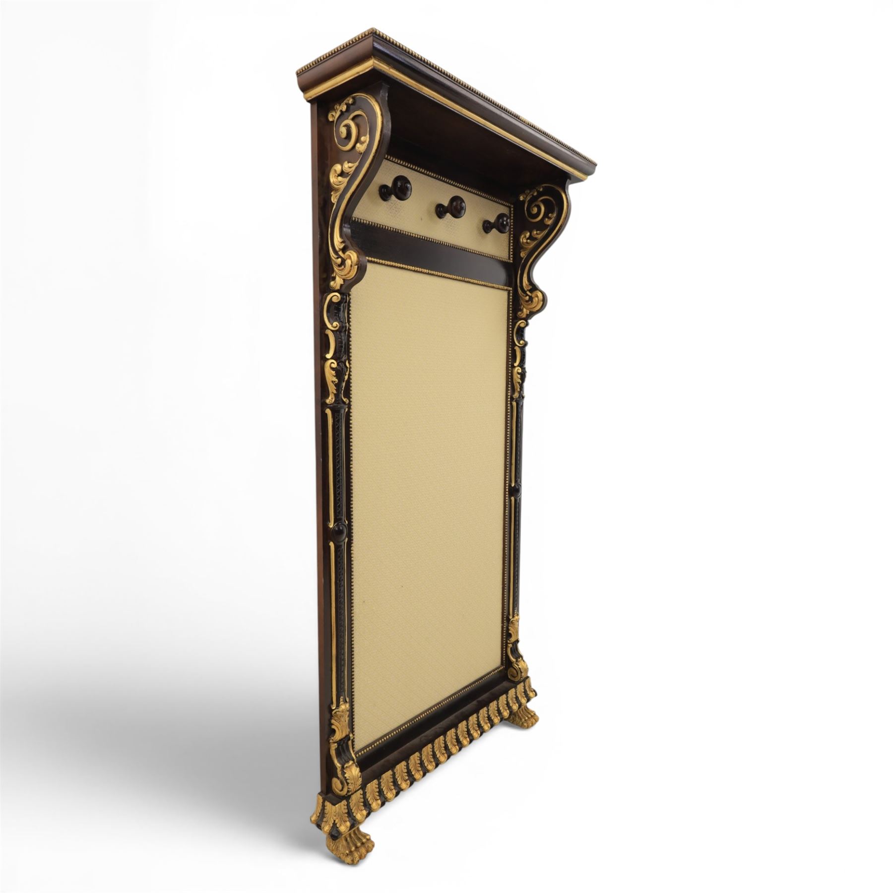 Empire design ebonised and parcel gilt hall stand, projecting moulded cornice with bead and reel border, upper rail fitted with three turned hat and coat pegs, central cream upholstered panel within beaded slip, flanked by scrolled uprights with gilt foliate and anthemion mounts, lower acanthus leaf apron, on paw feet