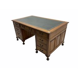 Early to mid 20th century mahogany twin pedestal desk, the rectangular top with gadroon carved edge and leather inset, on two panelled pedestals, fitted with nine drawers, on ball and claw carved feet