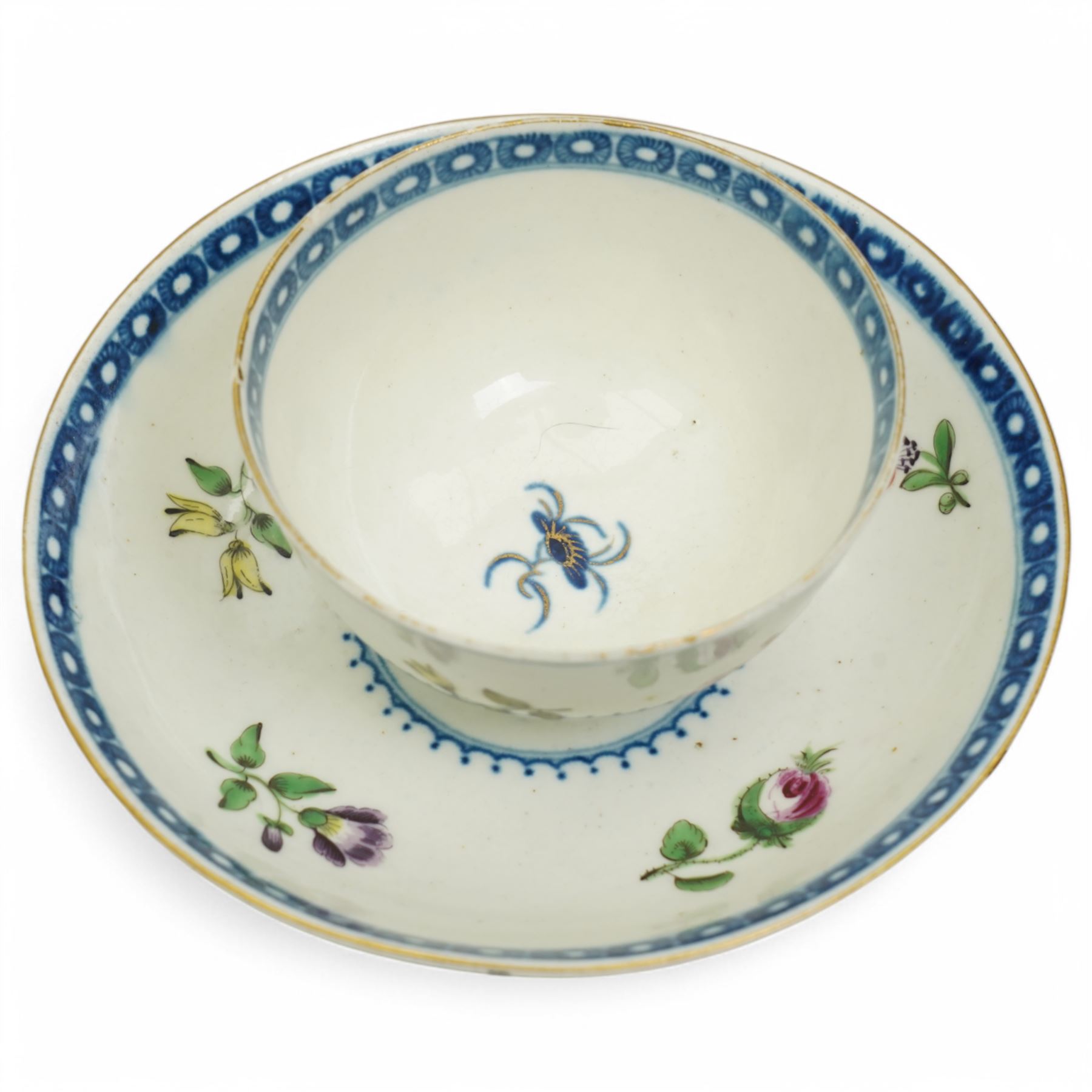 Worcester tea bowl and saucer, c.1770, painted with polychromatic floral sprays within blue borders, bearing crescent marks to base, with another similar early example, unmarked