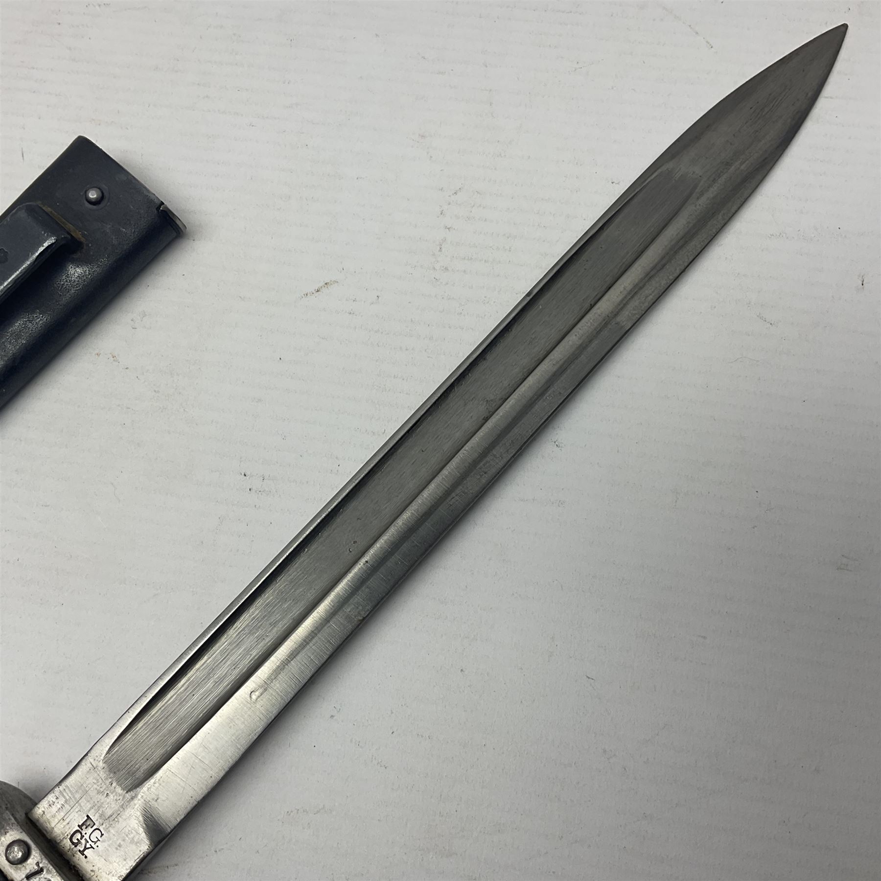 Austrian Model 1895 Carbine knife bayonet with 24.5cm fullered steel blade; various marks to the ricasso including F.G. GY.; cross-piece marked No.7843; in steel scabbard L37cm overall