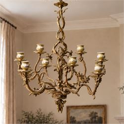 Rococo design brass ten light chandelier with scroll branches and ceramic candle holders H74cm