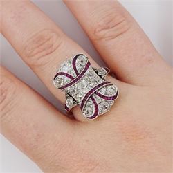 Early 20th century gold and platinum ruby and diamond panel ring, the principal old cut diamond of approx 0.30 carat, with old cut diamond surround and milgrain set calibre cut ruby ribbon motif, the tulip head shoulders set with a further diamond and ruby, total diamond weight approx 1.75 carat